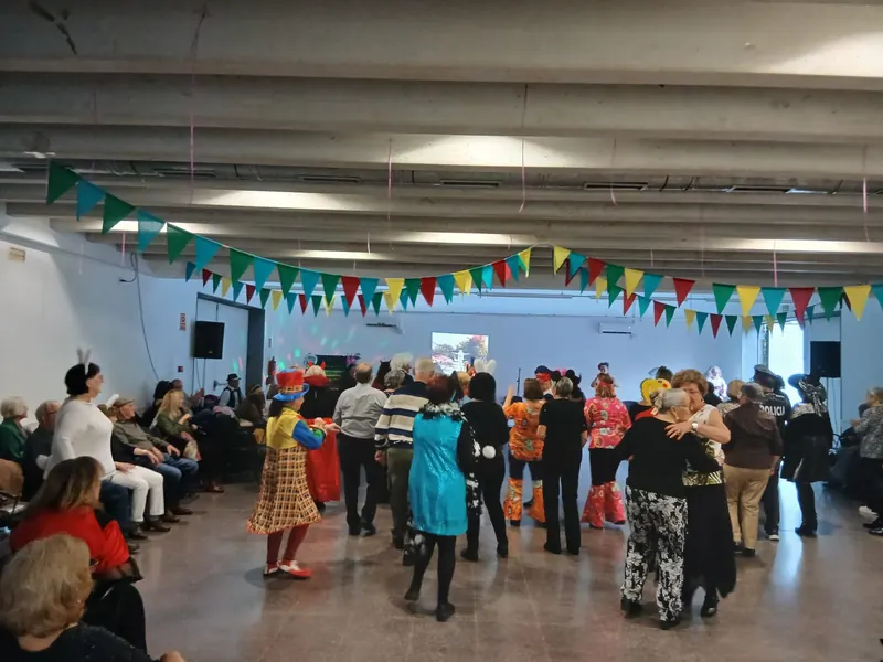 Fiesta de Carnaval: el público, disfrazado, baila en una sala decorada con banderines.